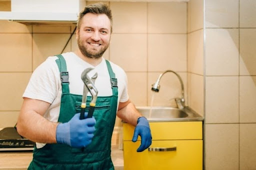 plumber posing for a picture beside faucet